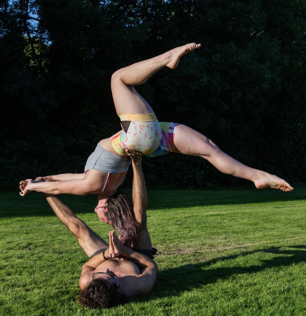 Elvan Nur die een partner acrobatiek oefening doet, wat zijn expertise in lichaamswerk toont.